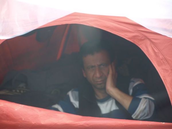 Solitary refugee sitting in his pup tent, Idomeni Refugee Camp, Idomeni, Greece.