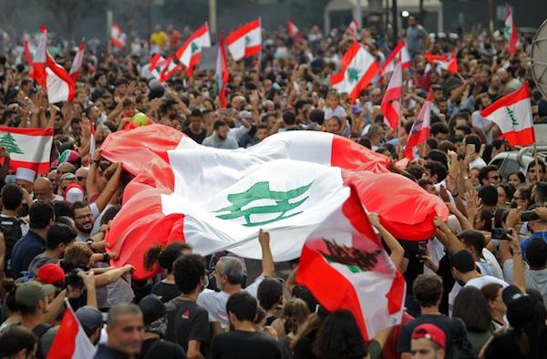 “Lebanese demonstrators wave the national flag during a protest against dire economic conditions in downtown Beirut, Oct. 18, 2019.” (Photo: “US News & World Report.”)