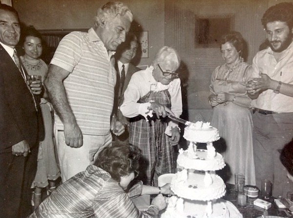 Jacky cutting her birthday cake with fierce determination.