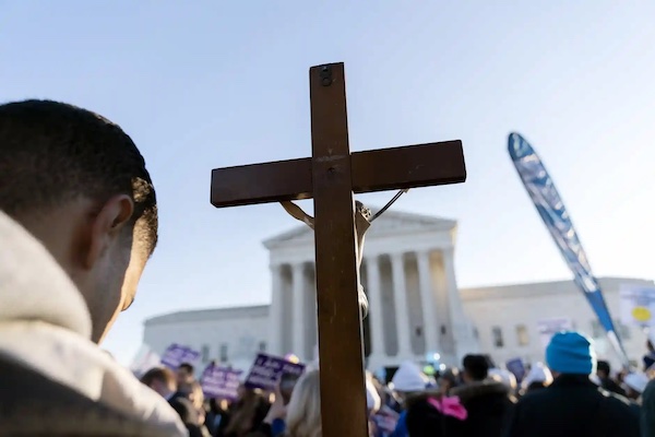 Anti-abortion protester in front of the Supreme Court as it hears arguments in case seeking to overturn Roe v Wade, December 2022. (Photo: José Luis Magaña/AP.)