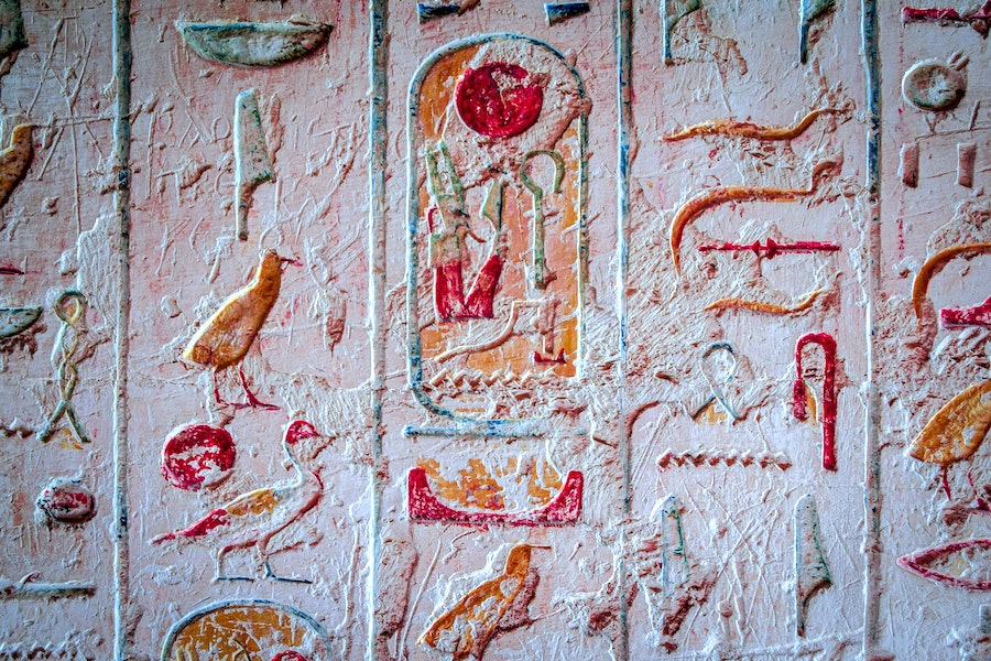 “Hieroglyphs in tomb of Pharaoh Ramesses IV,” via Unsplash, by Tom Podmore. 