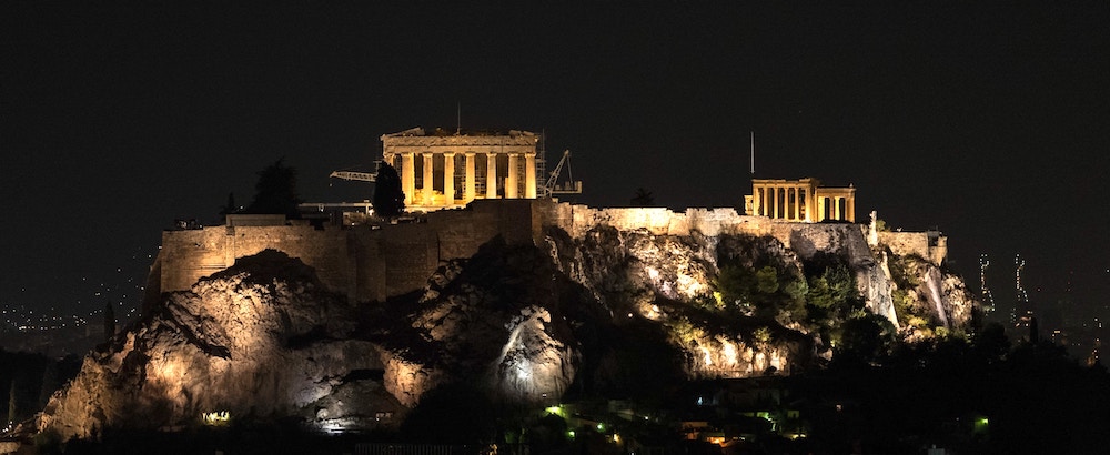The Parthenon at night. (Photo: AussieActive via Unsplash.)