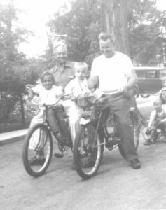 The author, aged three, in a bicycle basket.